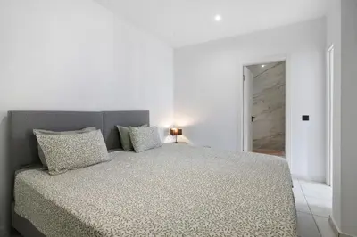 a white bedroom with a large bed with two pillows at Mi Casa Es Su Casa Nº4 in Albufeira