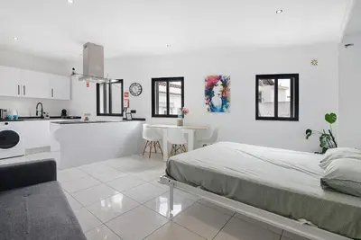 a white room with a bed and a kitchen at Mi Casa Es Su Casa Nº4 in Albufeira