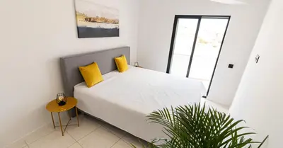 a kitchen and dining room with white walls and black chairs at Mi Casa Es Su Casa Nº5 in Albufeira