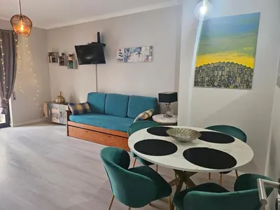 a living room with a table and a couch at Cartaia Apartamento Leste in Quarteira