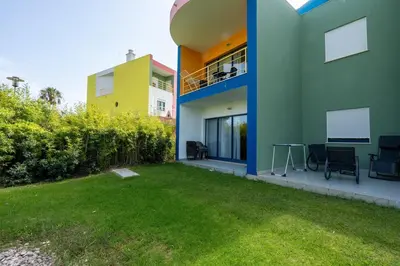 a house with a lawn in front of a building at APT T2 - Marina de Albufeira in Albufeira