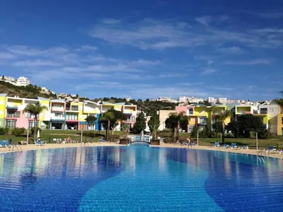 a large blue swimming pool with buildings in the background at APT T2 - Marina de Albufeira in Albufeira