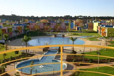 a bridge over a pool in a park with buildings at APT T2 - Marina de Albufeira in Albufeira