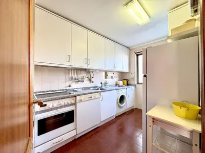 a kitchen with white cabinets and a washer and dryer at Vilamoura Central 12 With Pool by Homing in Vilamoura
