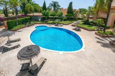 an overhead view of a swimming pool with chairs and umbrellas at Coastal Pines by Seareen in Quarteira