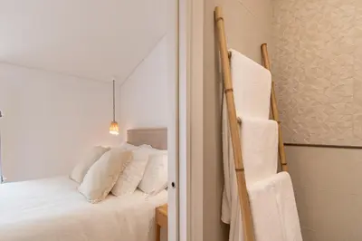 a room with a white bed with red and blue pillows at Casinha Amorosa in Faro