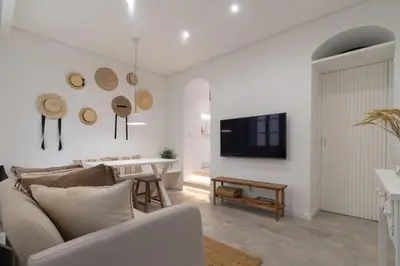 a kitchen with white cabinets and a clock on the wall at Casinha Amorosa in Faro
