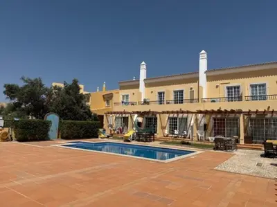 a large building with a swimming pool in front of it at Townhouse Sol&Mar Vilamoura in Vilamoura
