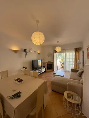 a living room with a table and a couch at Townhouse Sol&Mar Vilamoura in Vilamoura
