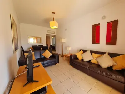 a living room with a couch and a tv at Encosta Sao Jose - Apartment BF in Albufeira
