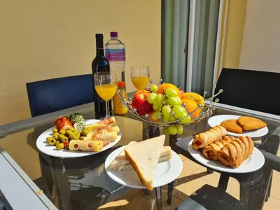 a glass table with two plates of food and wine at Encosta Sao Jose - Apartment BF in Albufeira