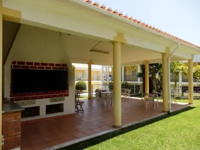 a covered patio with a fireplace and a large screen tv at Encosta Sao Jose - Apartment BF in Albufeira