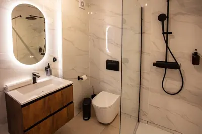 a bathroom with a shower and a toilet and a sink at Go4Portugal - Solaina - Modern Condo with AC and Private Balcony in Albufeira