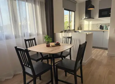 a kitchen and dining room with a wooden table and chairs at Go4Portugal - Solaina - Modern Condo with AC and Private Balcony in Albufeira