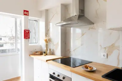 a white kitchen with a sink and a stove at Golden Nest - Faro Old Town in Faro