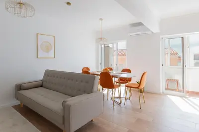 a living room with a couch and a table and chairs at Golden Nest - Faro Old Town in Faro