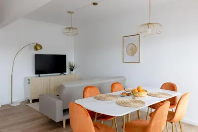 a dining room with a white table and orange chairs at Golden Nest - Faro Old Town in Faro