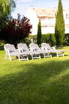 a row of white chairs sitting in the grass at Apartamento T2 duplex - Vilamoura in Quarteira