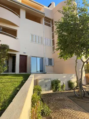 a large white building with a tree in front of it at Apartamento T2 duplex - Vilamoura in Quarteira