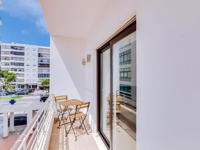 a balcony with a table and chairs on a building at T2 Moderno e Renovado a 500m da praia de Quarteira in Quarteira