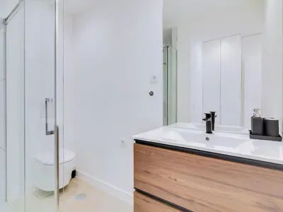 a bathroom with a white sink and a shower at T2 Moderno e Renovado a 500m da praia de Quarteira in Quarteira