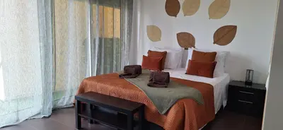 a bedroom with a bed with orange pillows and a window at Sossego a Sul in Albufeira