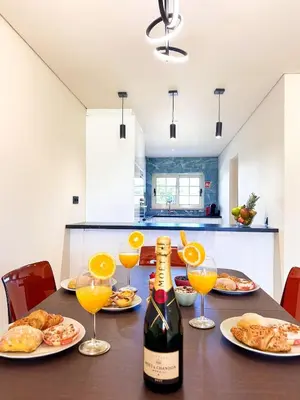 a table with plates of food and a bottle of wine at Oura Modern Poolside Condo by BeCherish in Vale de Pedras