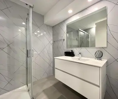 a white bathroom with a sink and a shower at The Navigator Olympus in Quarteira