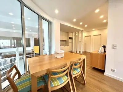 a kitchen and dining room with a wooden table and chairs at The Navigator Olympus in Quarteira