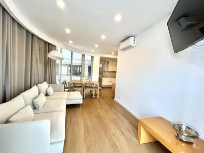 a living room with a white couch and a table at The Navigator Olympus in Quarteira