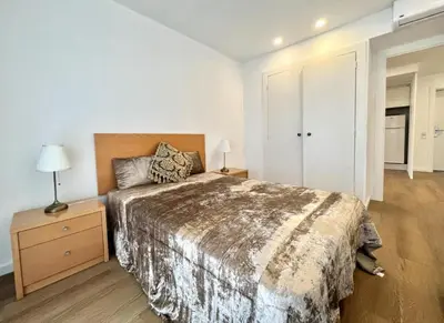 a bedroom with a bed and a night stand with a lamp at The Navigator Olympus in Quarteira