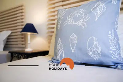 a pillow with a fish painted on it on a bed at #240 Beach House - Casa da Balaia by Home Holidays in Olhos de Água