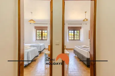 a room with two beds and a mirror at #240 Beach House - Casa da Balaia by Home Holidays in Olhos de Água