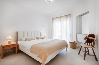a white table with two chairs and plates on it at Clube Albufeira - 2BR Pool, Kids Club & Family Fun in Albufeira