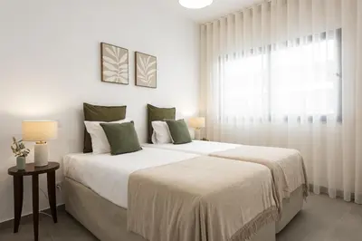 a white bedroom with a large bed and a window at Castilhos 1 - City center by HD in Faro