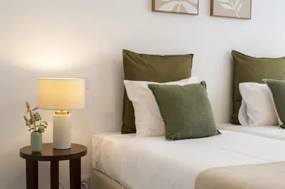 a bedroom with two beds with green and white pillows at Castilhos 1 - City center by HD in Faro