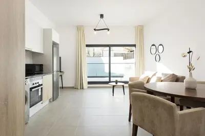 a kitchen and living room with a table and a couch at Castilhos 2 - City center by HD in Faro