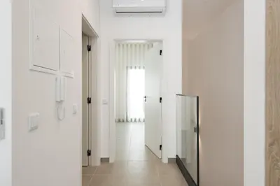 a hallway with white walls and a glass door at Castilhos 2 - City center by HD in Faro