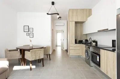 a kitchen with a table and a dining room at Castilhos 2 - City center by HD in Faro
