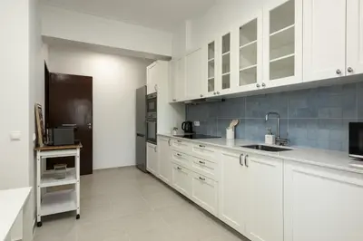 a kitchen with white cabinets and a black refrigerator at Salty - Near the city by HD in Faro