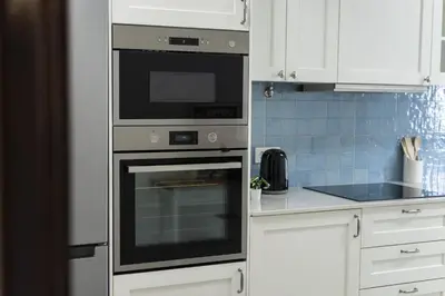 a kitchen with a stainless steel oven and white cabinets at Salty - Near the city by HD in Faro