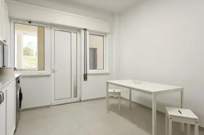 a kitchen with a white table and a table and chairs at Salty - Near the city by HD in Faro