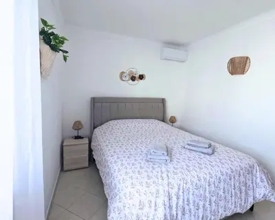 a bedroom with a bed with two towels on it at O Canto do Oceano T2 Albufeira in Albufeira