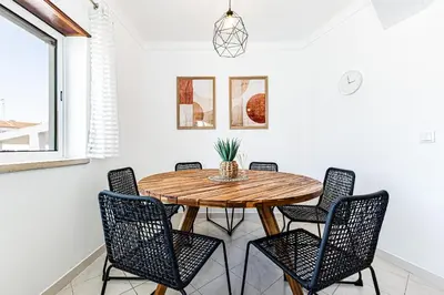 a dining room with a wooden table and chairs at O Canto do Oceano T2 Albufeira in Albufeira