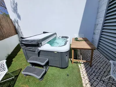a hot tub and a table on a patio at Luxury Design Villa (Private Pool & Jacuzzi) in Albufeira