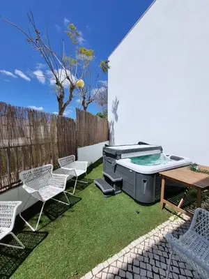 a backyard with a grill and chairs and a table at Luxury Design Villa (Private Pool & Jacuzzi) in Albufeira
