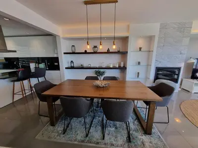 a dining room and kitchen with a wooden table and chairs at Luxury Design Villa (Private Pool & Jacuzzi) in Albufeira