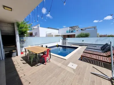 a patio with a table and chairs and a pool at Luxury Design Villa (Private Pool & Jacuzzi) in Albufeira