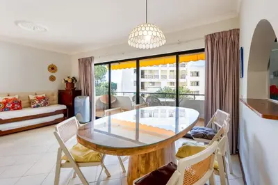 a dining room with a glass table and chairs at 2 BDR Flat With Pool in Vilamoura by LovelyStay in Quarteira