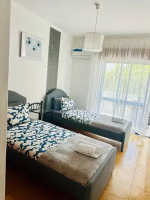 a bedroom with a bed and a dresser and a window at Milennium Holiday Apartment in Quarteira